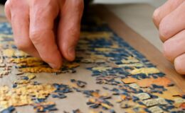 Completed jigsaw puzzle beside sorted pieces and a reference image
